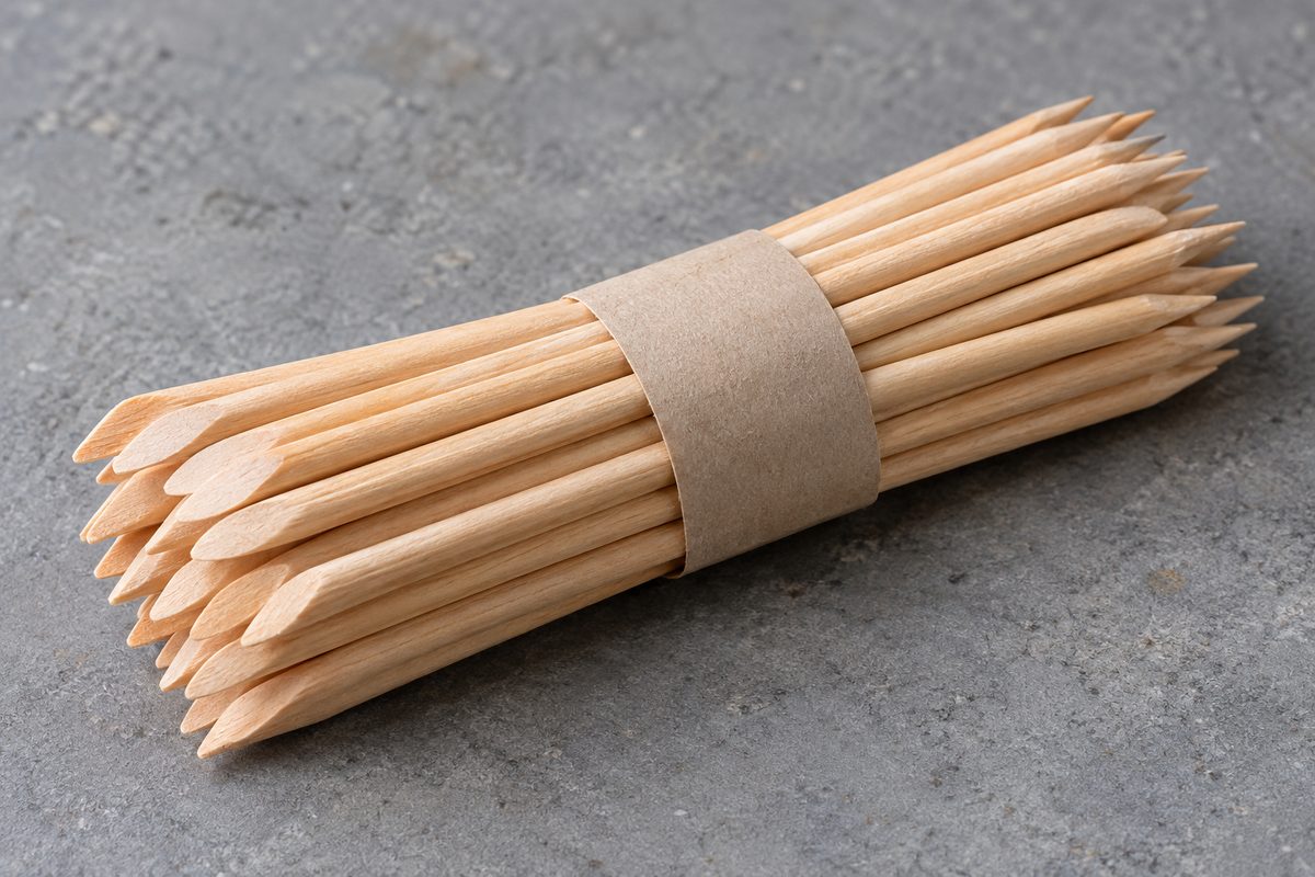 Neat bundle of double-ended orange wood cuticle sticks showing angled beveled edges